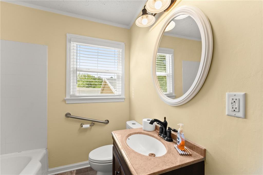 6455 Main Street Lula, GA 30554 - Photo 23 of 43 a bathroom with a toilet a sink a mirror and a window