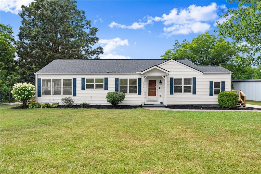6455 Main Street Lula, GA 30554 - Photo 3 of 43 a front view of a house with a garden