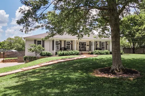 a view of kitchen with kitchen island wooden floor and stainless steel appliances