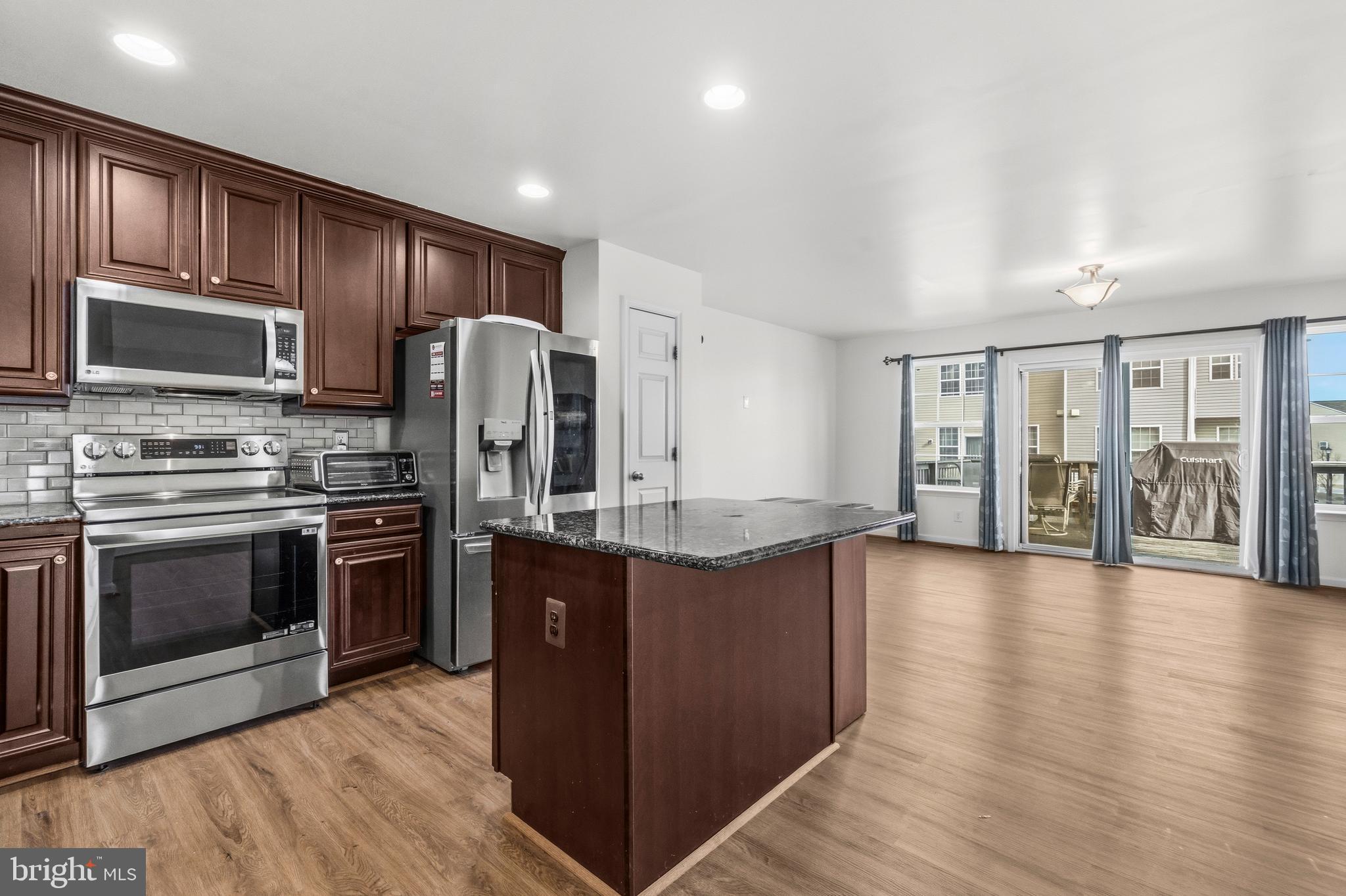 31 Wayside Court Falling Waters, WV 25419 - Photo 10 of 36 a kitchen with stainless steel appliances granite countertop a stove a sink dishwasher a refrigerator and a microwave oven with wooden floor