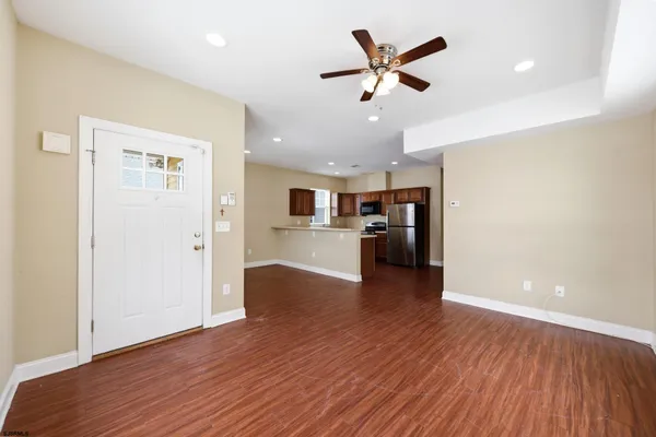 a view of a big room with wooden floor and a ceiling fan
