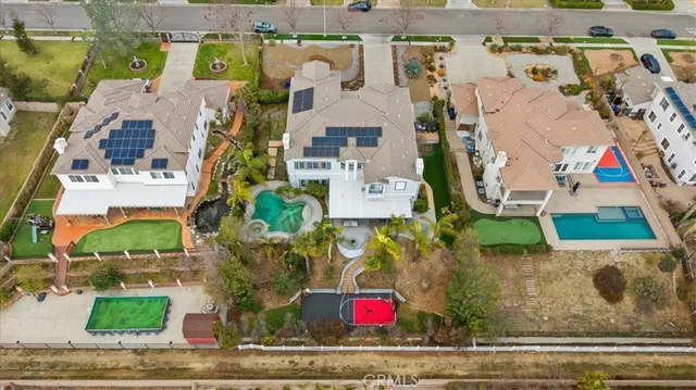 an aerial view of a residential houses with outdoor space and ocean view