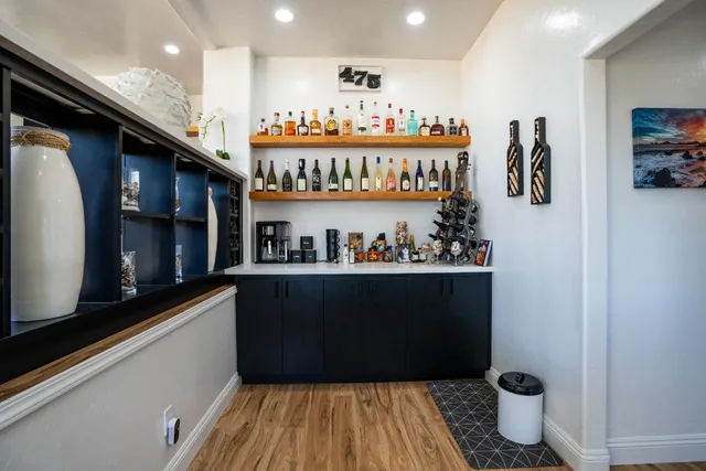 a view of a hallway with wooden floor and a bathroom