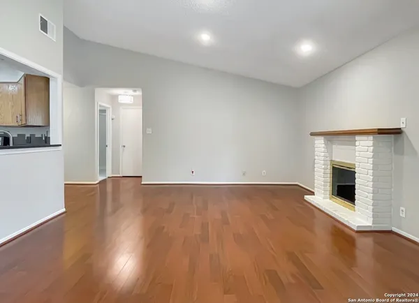 an empty room with wooden floor and bathroom