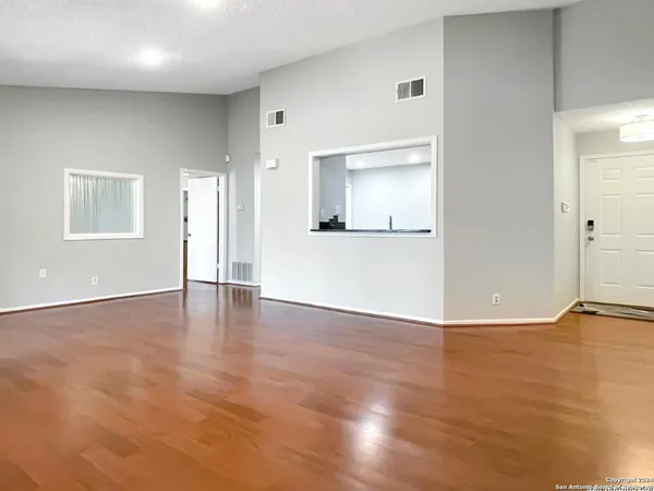 a view of empty room with wooden floor
