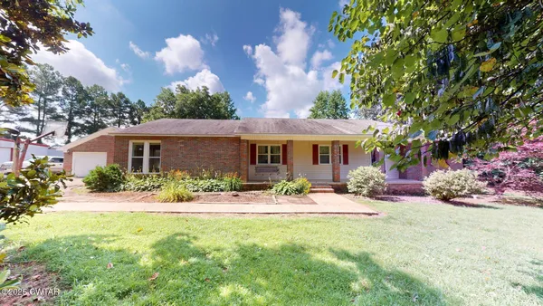 a front view of a house with yard porch and outdoor seating