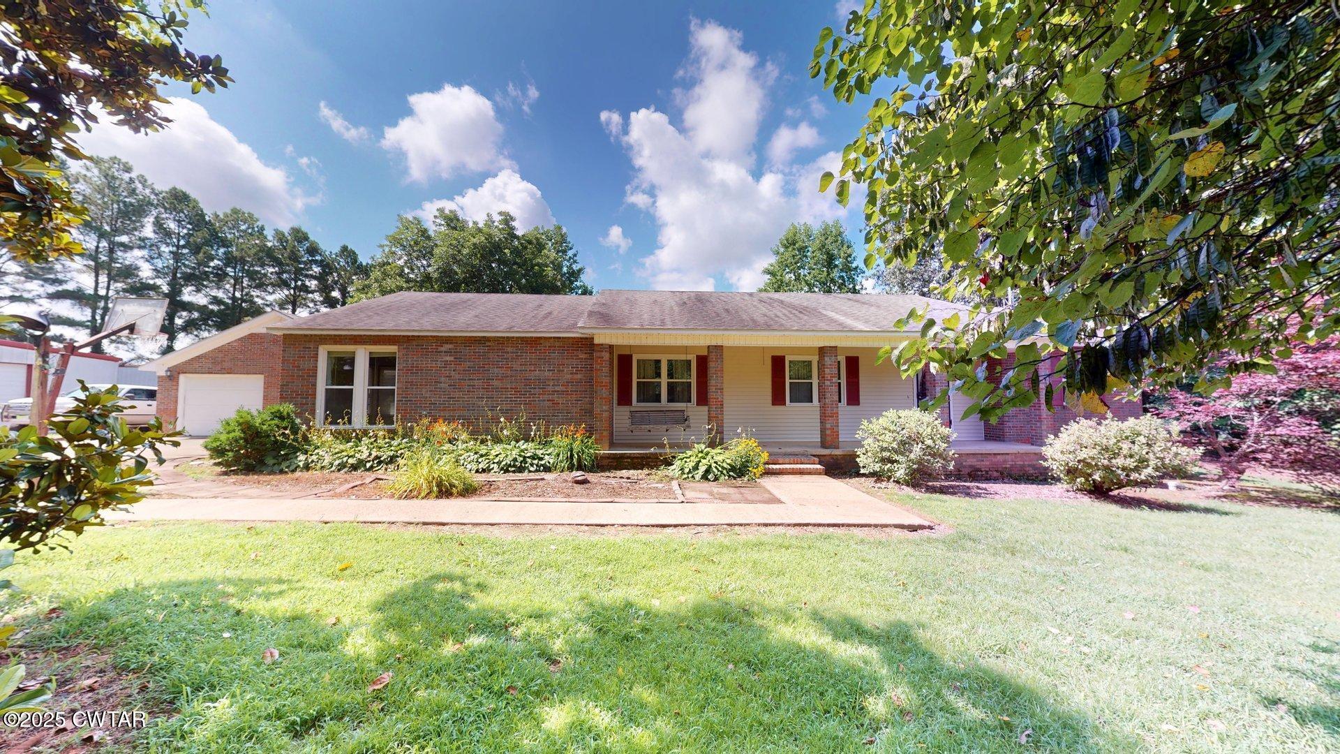 a front view of a house with yard porch and outdoor seating