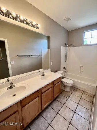 a bathroom with a double vanity sink mirror and toilet