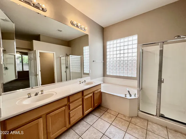 a bathroom with a granite countertop sink mirror and bathtub