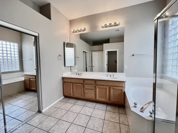 a spacious bathroom with a granite countertop sink mirror and bathtub