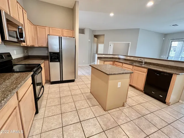 a kitchen with stainless steel appliances granite countertop a stove a sink and a refrigerator