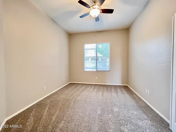 an empty room with windows and fan