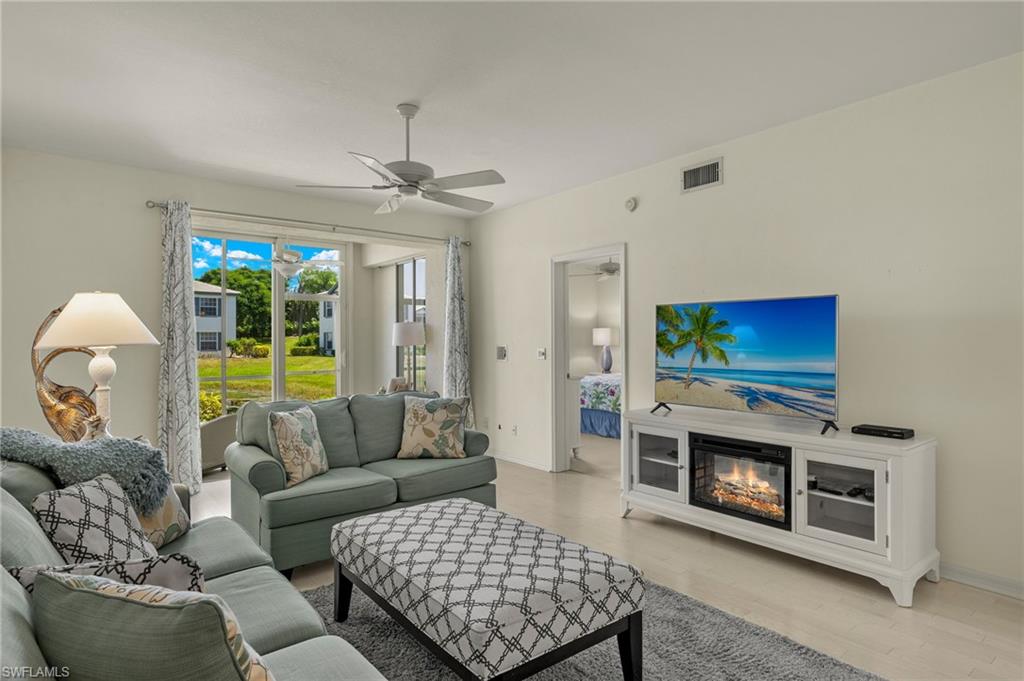 824 Tanbark Drive, Unit 104 Naples, FL 34108 - Photo 3 of 17 a living room with furniture a flat screen tv and a fireplace