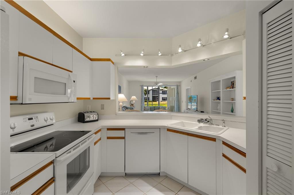824 Tanbark Drive, Unit 104 Naples, FL 34108 - Photo 5 of 17 a kitchen with a sink stove and cabinets