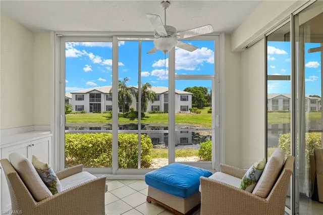 a living room with furniture and a floor to ceiling window