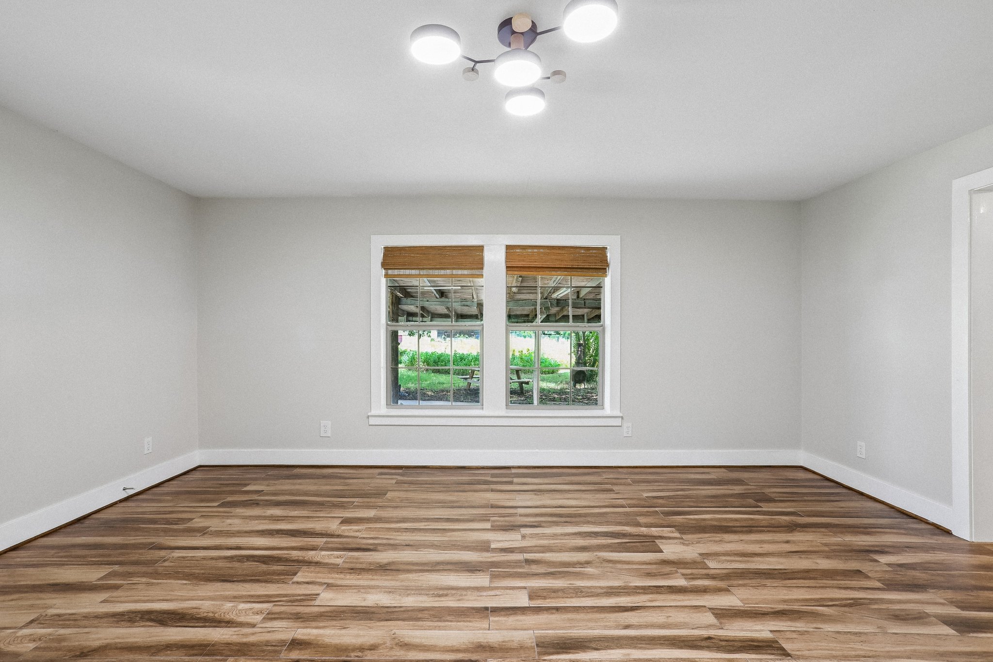 2089 Farm To Market Road 1704 Elgin, TX 78621 - Photo 5 of 31 Bright interior space features fresh wood plank flooring and a modern overhead light fixture.