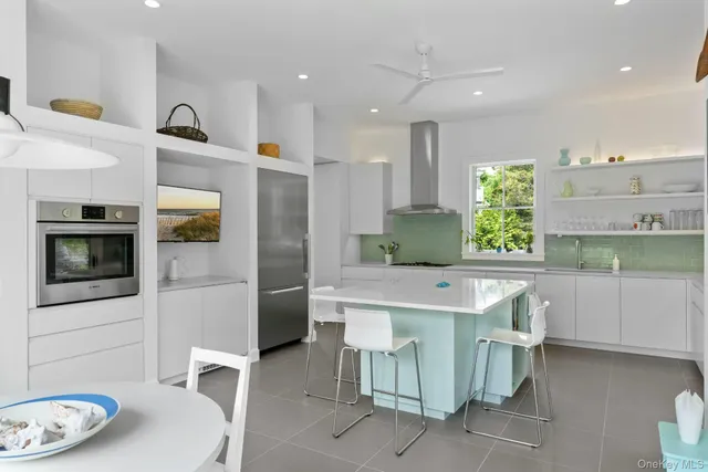 a kitchen with stainless steel appliances a microwave a stove and white cabinets