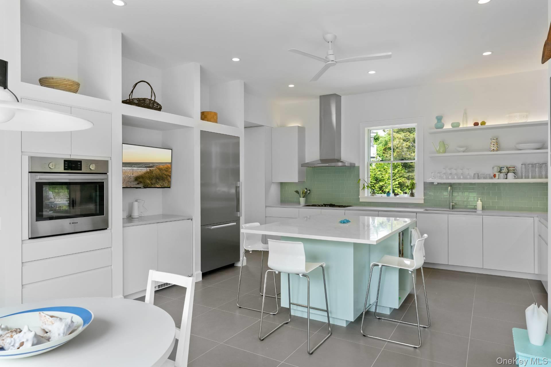 26 Georgian Lane Water Mill, NY 11976 - Photo 12 of 45 a kitchen with stainless steel appliances a microwave a stove and white cabinets