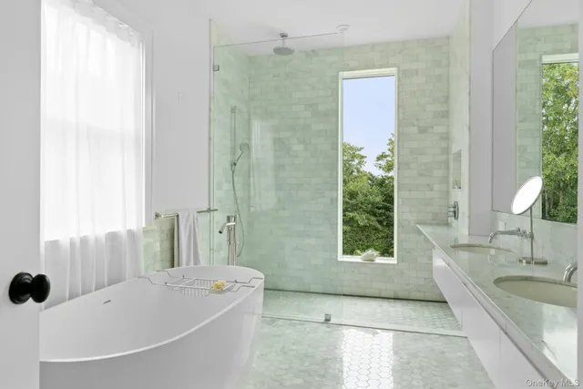 a bathroom with a tub sink and mirror