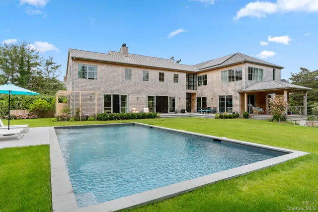 a view of house with swimming pool and yard
