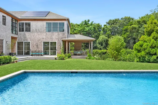 a front view of a house with a yard and potted plants