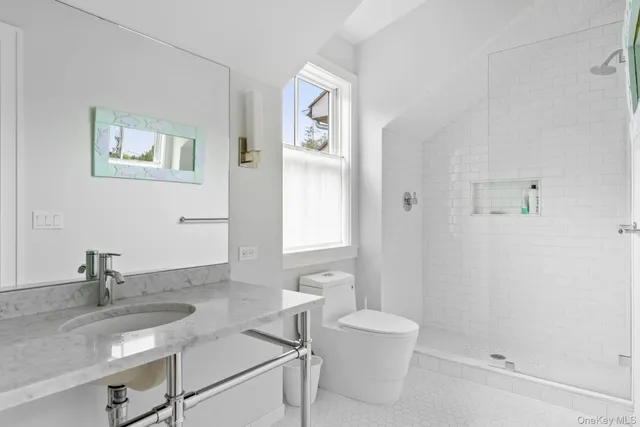 a bathroom with a granite countertop sink mirror vanity and toilet