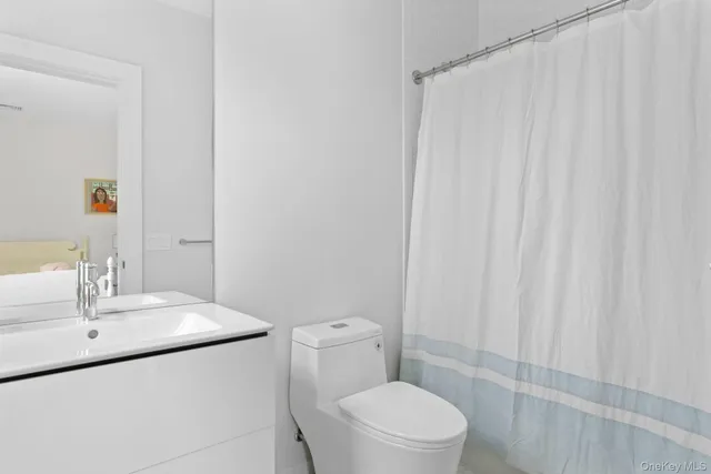 a bathroom with a sink a toilet and shower curtain