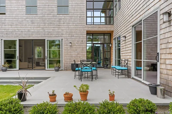 a view of a patio with table and chairs and potted plants