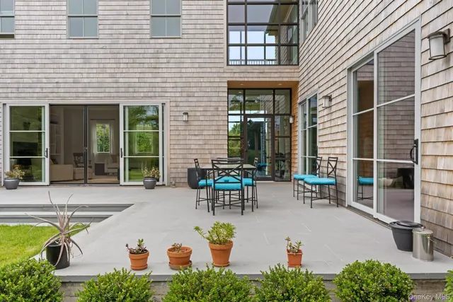 a view of a patio with table and chairs and potted plants