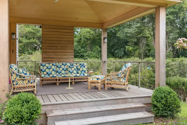 a view of a patio with table and chairs potted plants and floor to ceiling window