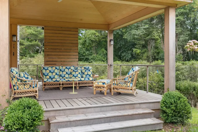 a view of a patio with table and chairs potted plants and floor to ceiling window