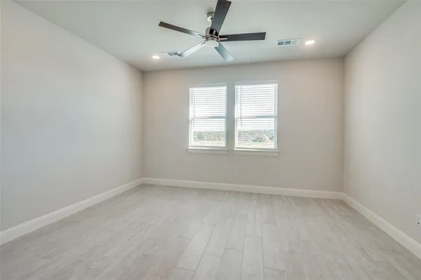 an empty room with a window and a fan