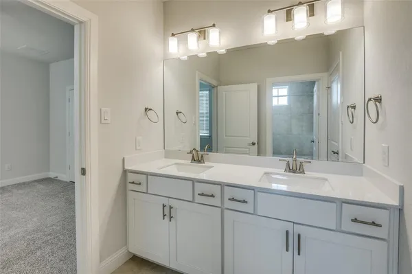a bathroom with double sink and a mirror