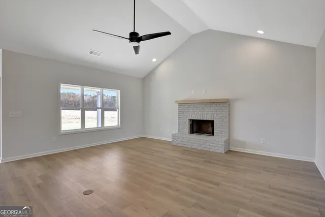 a view of an empty room with glass door and wooden floor
