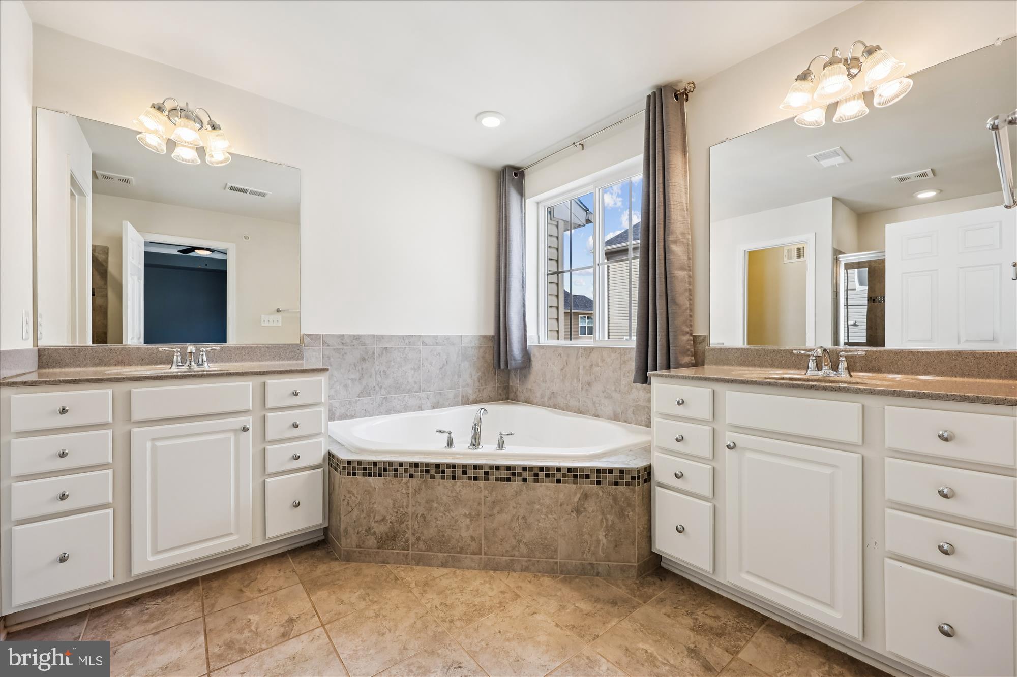 6146 Murray Terrace Frederick, MD 21703 - Photo 16 of 53 a spacious bathroom with a tub double sink and mirror