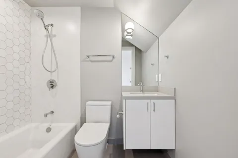 a bathroom with a granite countertop sink a toilet and shower