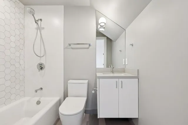 a bathroom with a granite countertop sink a toilet and shower