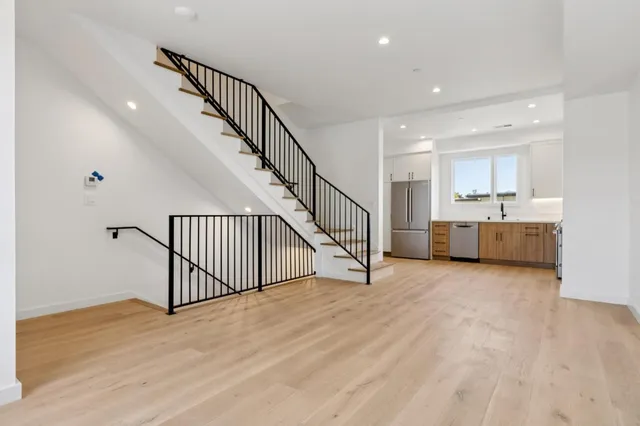 a view of a kitchen with wooden floor and stairs