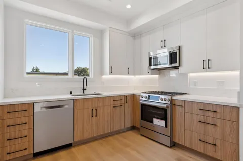 a kitchen with white cabinets stainless steel appliances and sink