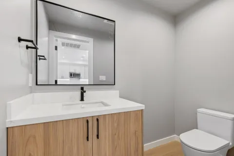 a bathroom with a sink toilet and mirror