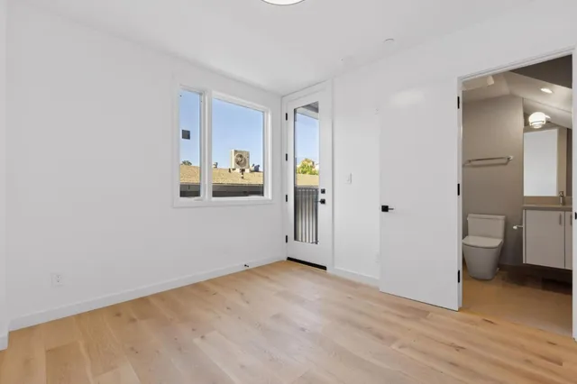 a view of a room with wooden floor and a bathroom