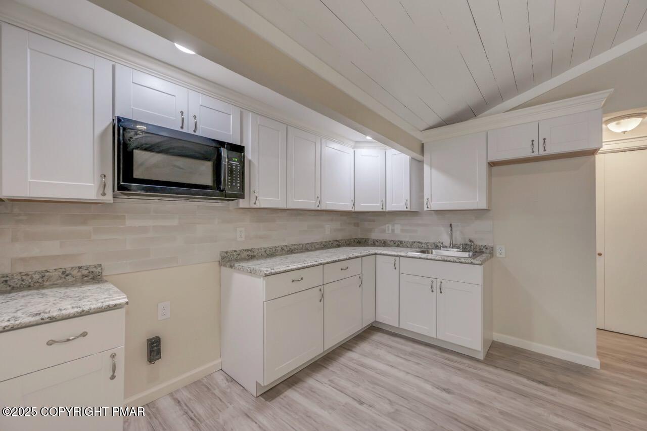 2128 Faratol Road East Stroudsburg, PA 18302 - Photo 68 of 85 a kitchen with granite countertop white cabinets stainless steel appliances a sink and wooden floor