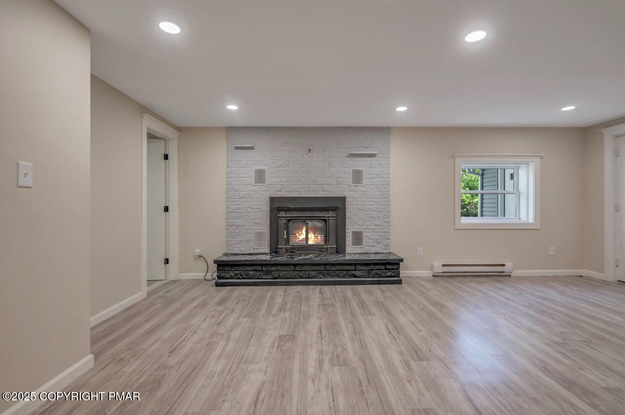 2128 Faratol Road East Stroudsburg, PA 18302 - Photo 10 of 85 a view of an empty room with wooden floor and a fireplace