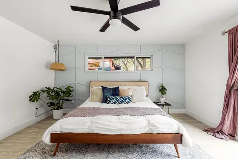 a bedroom with a bed potted plant with the window