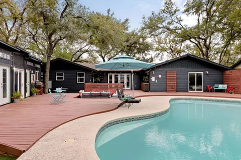 a view of a house with swimming pool and sitting area