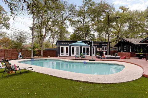 a backyard of a house with fire pit and chairs