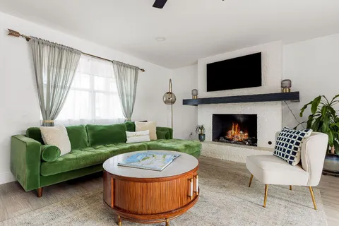 a living room with furniture a flat screen tv and a fireplace
