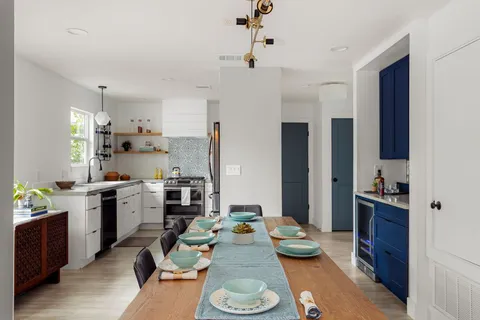 a large kitchen with a table chairs stove and refrigerator