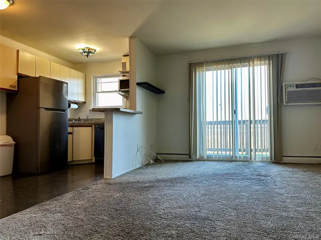 a sign board with flower garden and wooden fence