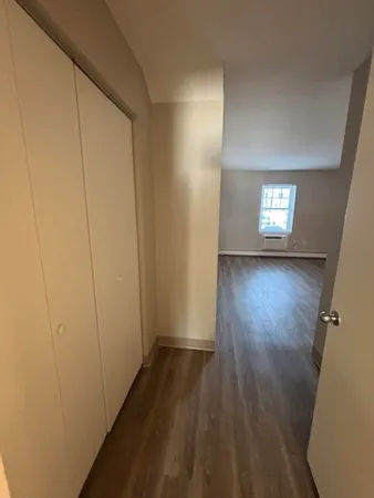 a view of a hallway with wooden floor and a window